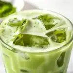 Iced matcha latte with vibrant green color served in a glass over ice.