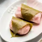 Sakura Mochi - traditional Japanese sweet pink rice cake with red bean paste and cherry blossom leaf.