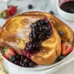 Delicious Sourdough French Toast with a golden, lacy exterior served on a plate.