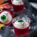 Spooky Halloween Eyeball Jello Shots with gummy eyeballs and vibrant colors.