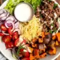 Delicious sweet potato burger bowl with roasted sweet potatoes and fresh ingredients.