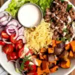 Delicious sweet potato burger bowl with roasted sweet potatoes and fresh ingredients.