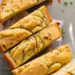 Deliciously crusty Sourdough Garlic Bread topped with garlic and herbs.