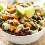 Quinoa sweet potato bowl topped with roasted chickpeas and avocado-lime dressing.