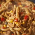 Crockpot Taco Pasta with ground beef, cheese, and colorful veggies in a slow cooker.
