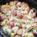 Garlic Parmesan Crockpot Chicken with tender potatoes in a creamy sauce.