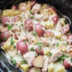 Garlic Parmesan Crockpot Chicken with tender potatoes in a creamy sauce.