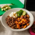 Delicious sweet potato hot honey bowl with ground beef, avocado, and spicy drizzle.