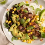 Delicious Cilantro Lime Steak Bowls with grilled steak, rice, avocado, and lime crema.