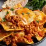 Crockpot Ravioli Lasagna with layered ravioli, meat sauce, and melted cheese.