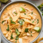 Bowl of high protein white chicken chili topped with herbs and served with tortilla chips.