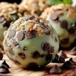 Mint chocolate chip protein balls with mint leaves and chocolate chips.
