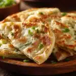 Crispy scallion pancakes (Cong You Bing) served on a plate with dipping sauce