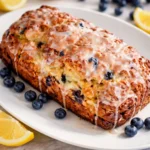 Loaf of Sourdough Blueberry Lemon Quick Bread with fresh blueberries and lemon zest.