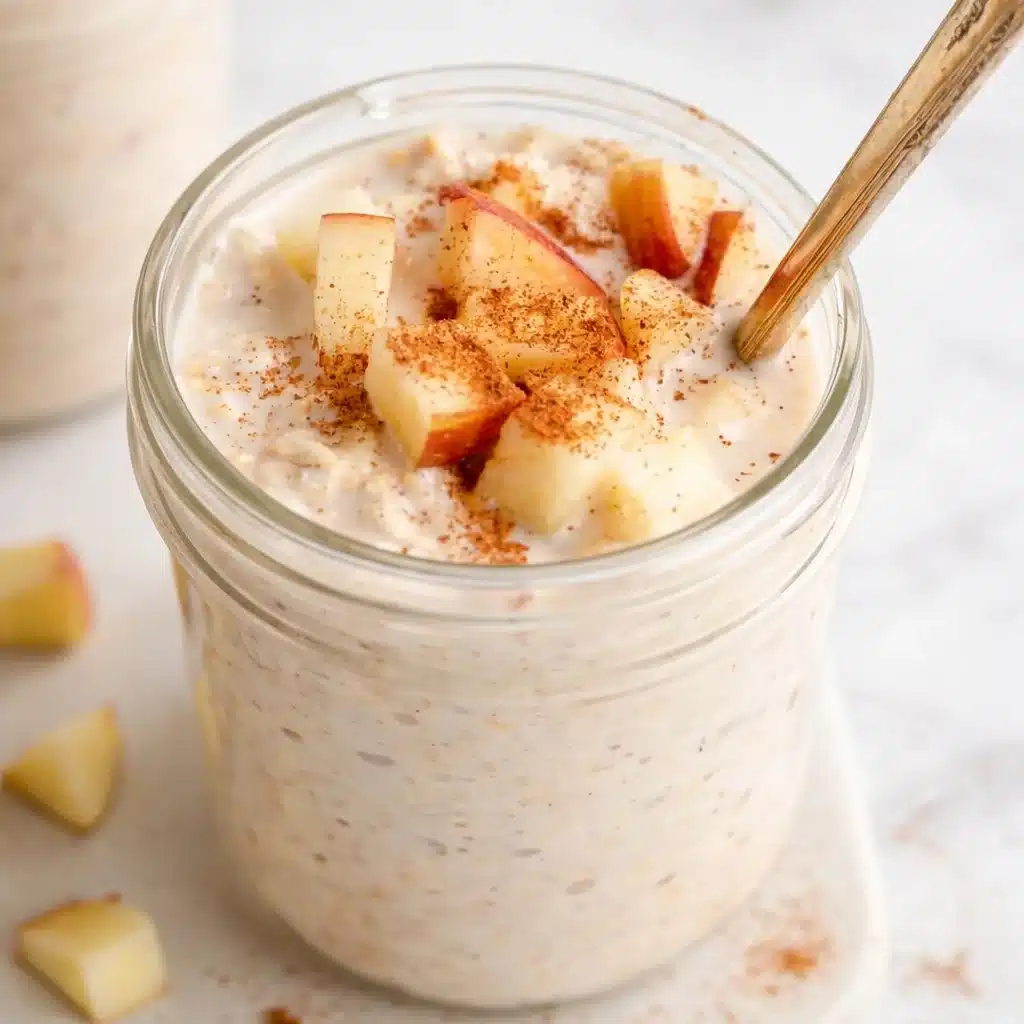 Delicious Apple Cinnamon Overnight Oats in a mason jar topped with fresh apples and cinnamon.