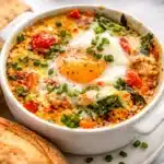 Mediterranean Baked Feta Eggs with tomatoes and herbs for a hearty breakfast.