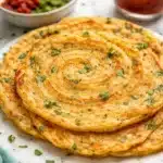 Vegan gluten-free red lentil pancakes stacked on a plate with fresh toppings