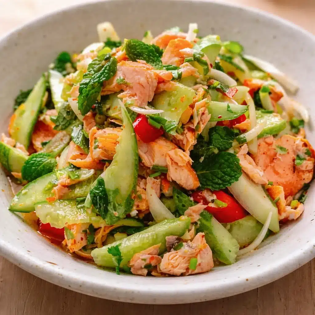 A vibrant Thai Style Salmon Salad with fresh herbs and a spicy dressing served in a bowl.