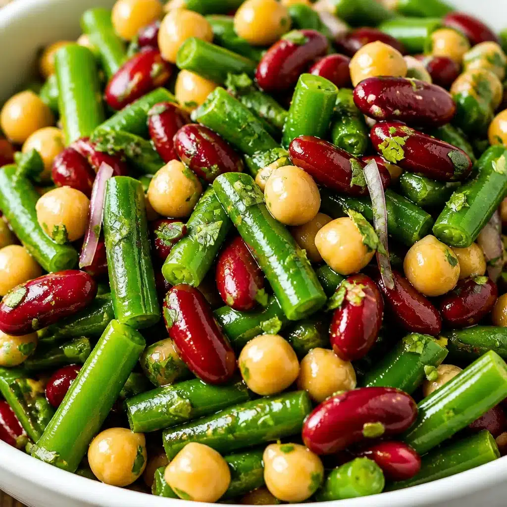Delicious Three Bean Salad with cannellini, kidney, and garbanzo beans mixed with celery and a tangy dressing.