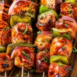 Grilled summer BBQ chicken with sides and fresh ingredients on a plate.