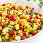 Colorful summer corn salad with fresh vegetables and feta cheese.