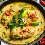 Thai Coconut Lime Chicken served with lime and coconut garnishes in a skillet.