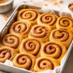 Delicious Pumpkin Cinnamon Rolls topped with cream cheese icing and pumpkin spice.