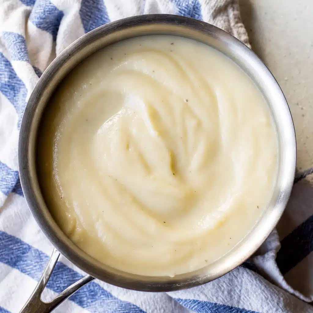 Creamy Vegan Cauliflower Alfredo Sauce poured over fettuccine with garnishes.