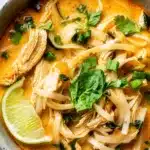 A bowl of Thai Chicken Curry Soup with coconut milk, red curry paste, and colorful fresh vegetables.