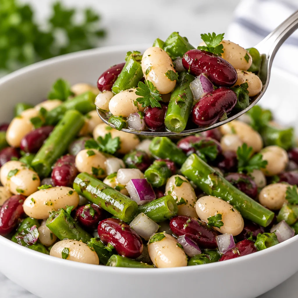 Colorful three bean salad with cannellini, kidney, and garbanzo beans in a tangy dressing.